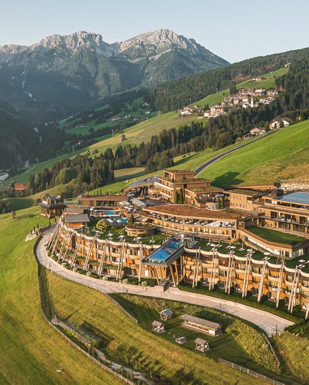 Our 5-star hotel in Italy between heaven and earth Luxury hotel on green hillside with Alpine mountains in the background