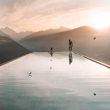The Hubertus in a short time-lapse Two people at an infinity pool overlooking mountains at sunset