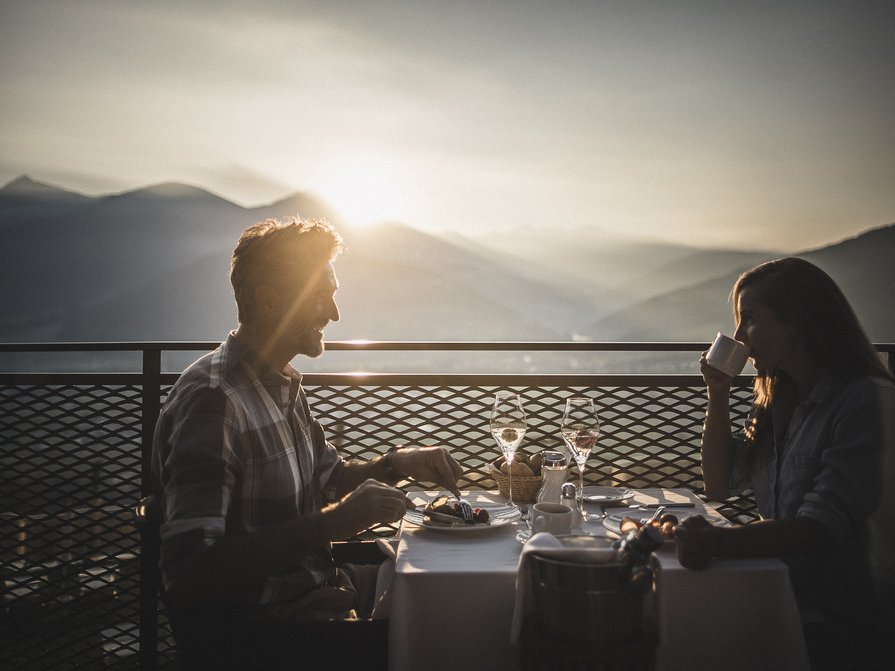 Unser Hotel in Olang zwischen Himmel und Erde Paar beim Frühstück mit Bergblick im Sonnenlicht