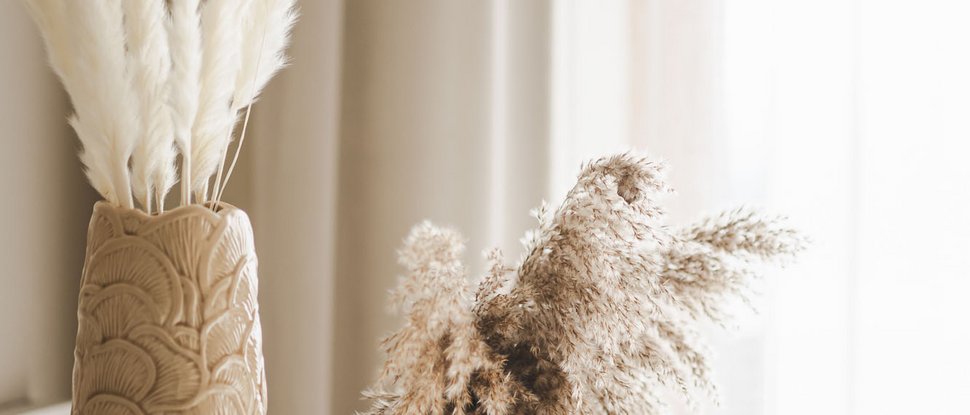 Unser Hotel in Olang zwischen Himmel und Erde Zwei dekorative Vasen mit getrockneten Pampasgras vor Vorhängen