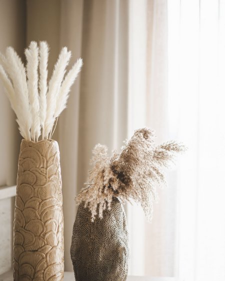 Unser Hotel in Olang zwischen Himmel und Erde Zwei dekorative Vasen mit getrockneten Pampasgras vor Vorhängen