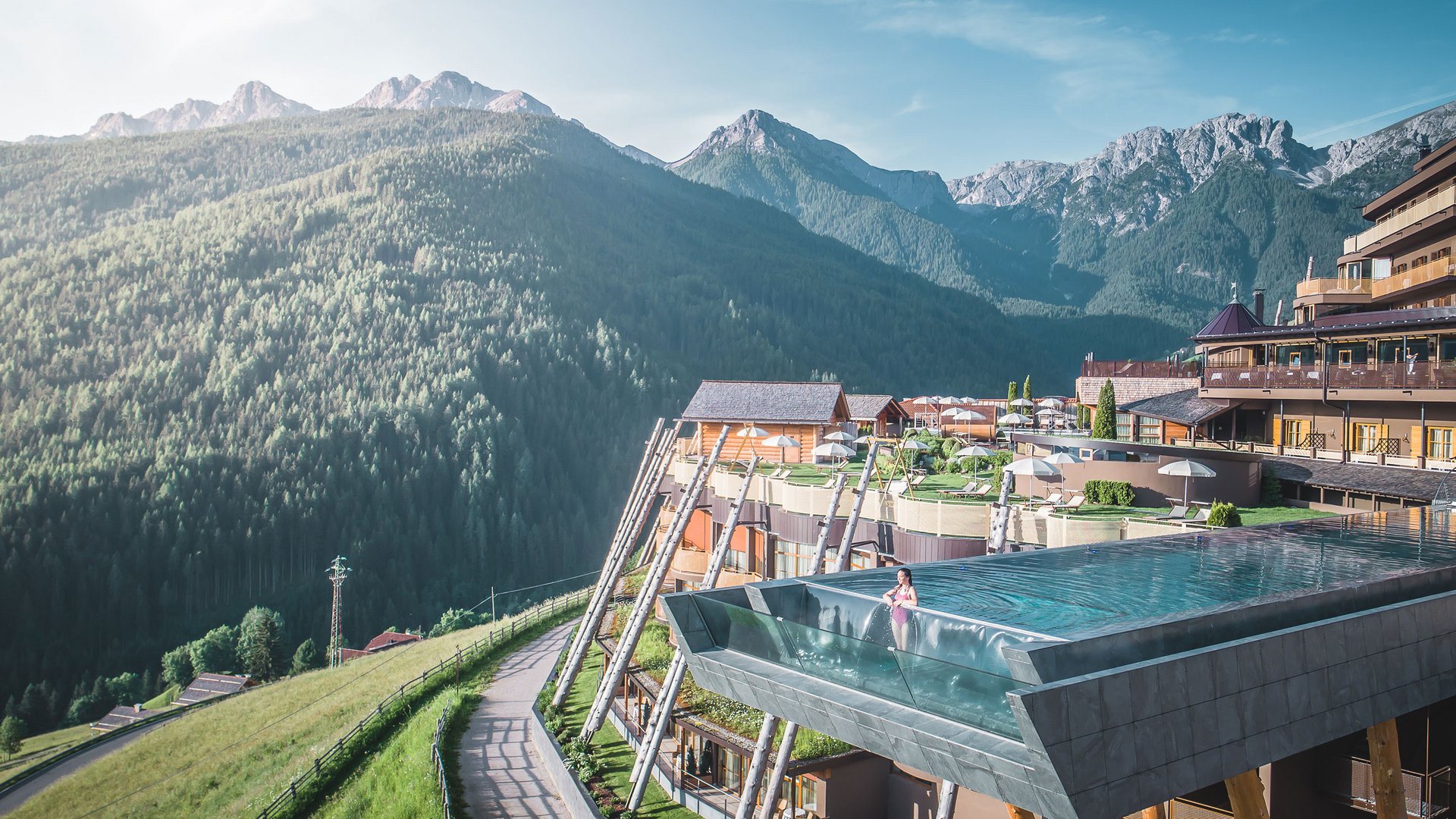 Change the world sip by sip Infinity pool at mountain resort overlooking forested alpine peaks