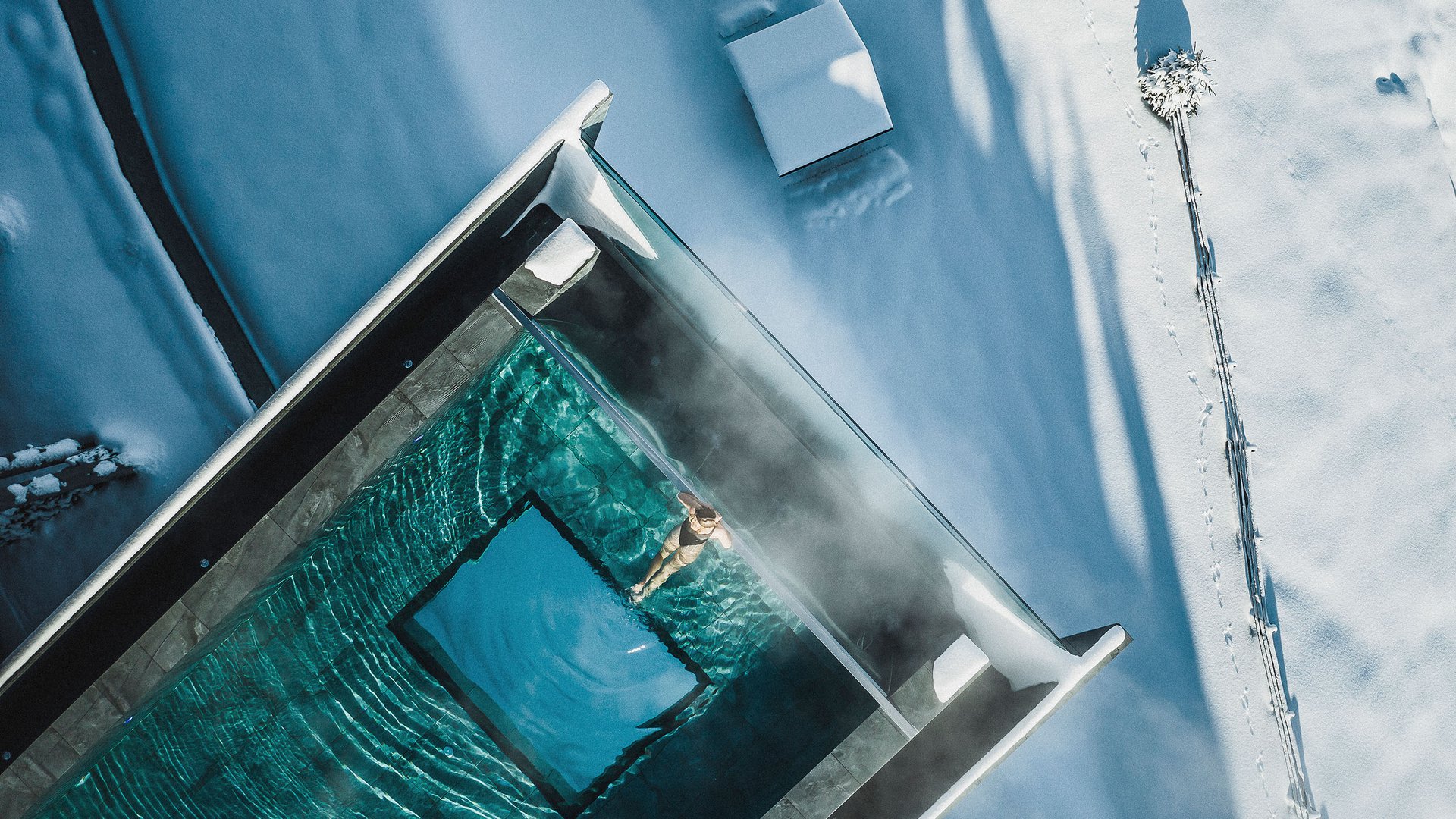 From Olang to the Lake Braies Person swimming in heated pool surrounded by snow and winter landscape